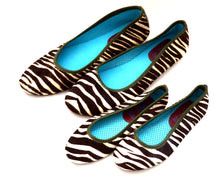 Mom and daughter zebra print shoes.